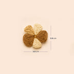 A woven flower-shaped hair accessory in three shades of brown and beige, shown with dimension lines indicating a width and height of 3.8 cm on a solid beige background.