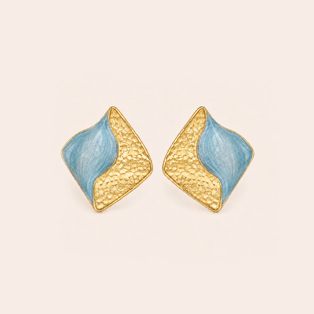 A pair of  light blue geometric stud earrings on a golden background.